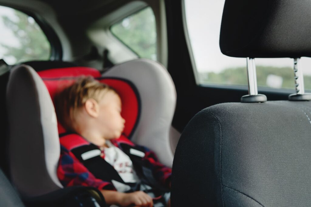 child sleeping in the backseat of a car